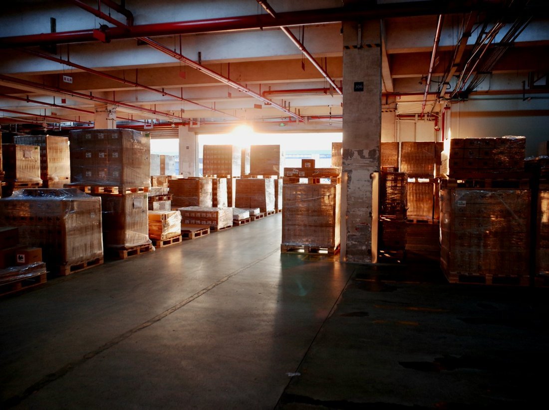 General warehouse interior with palletized, shrink-wrapped goods across 3 lakh+ sq.ft of storage